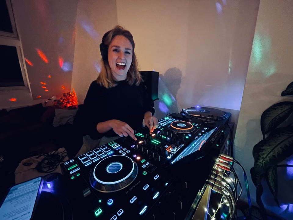 Maizie, also known as kiitsch, smiling behind the DJ decks